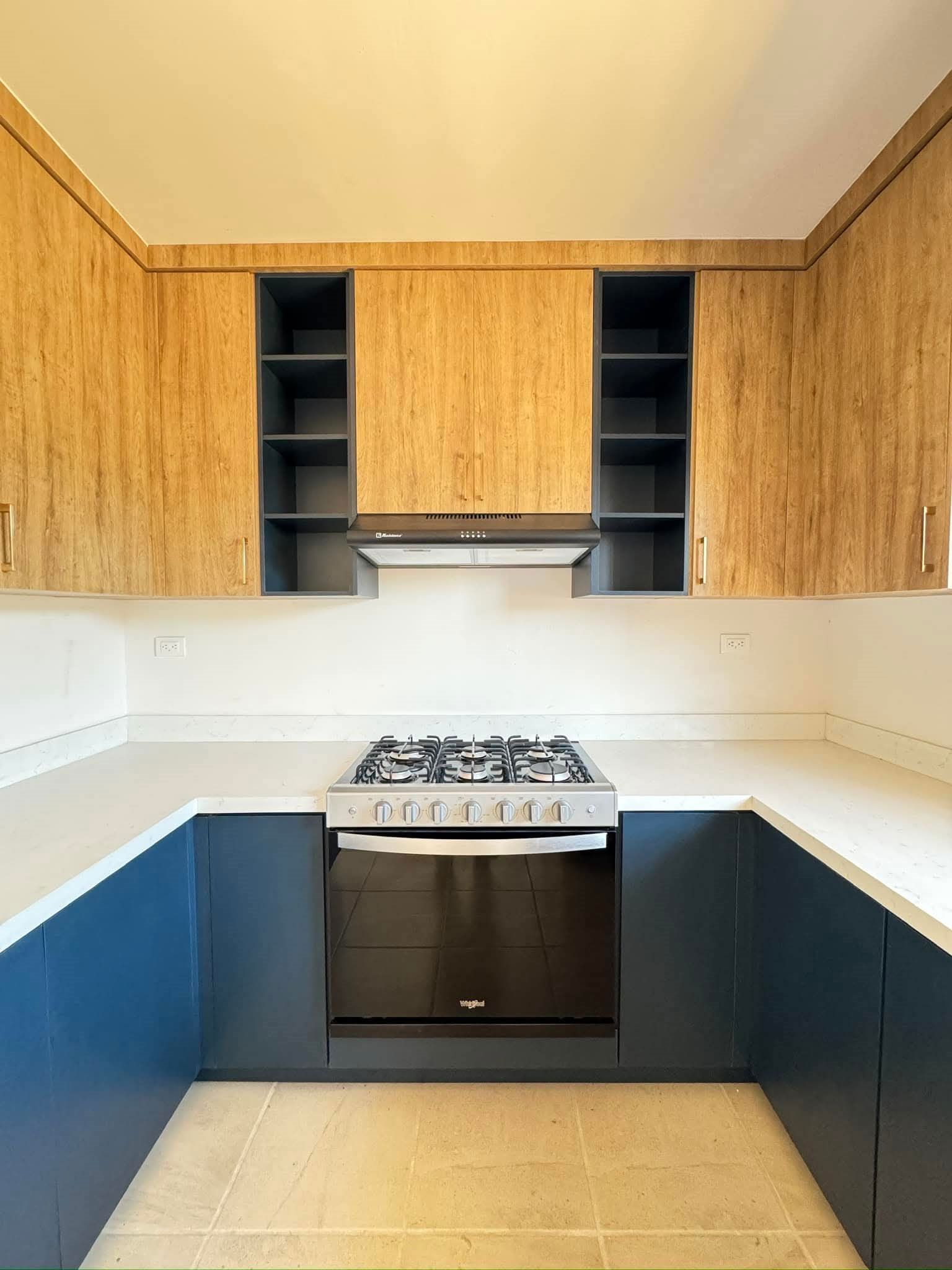 Cocina integral con alacenas de madera y gabinetes azules