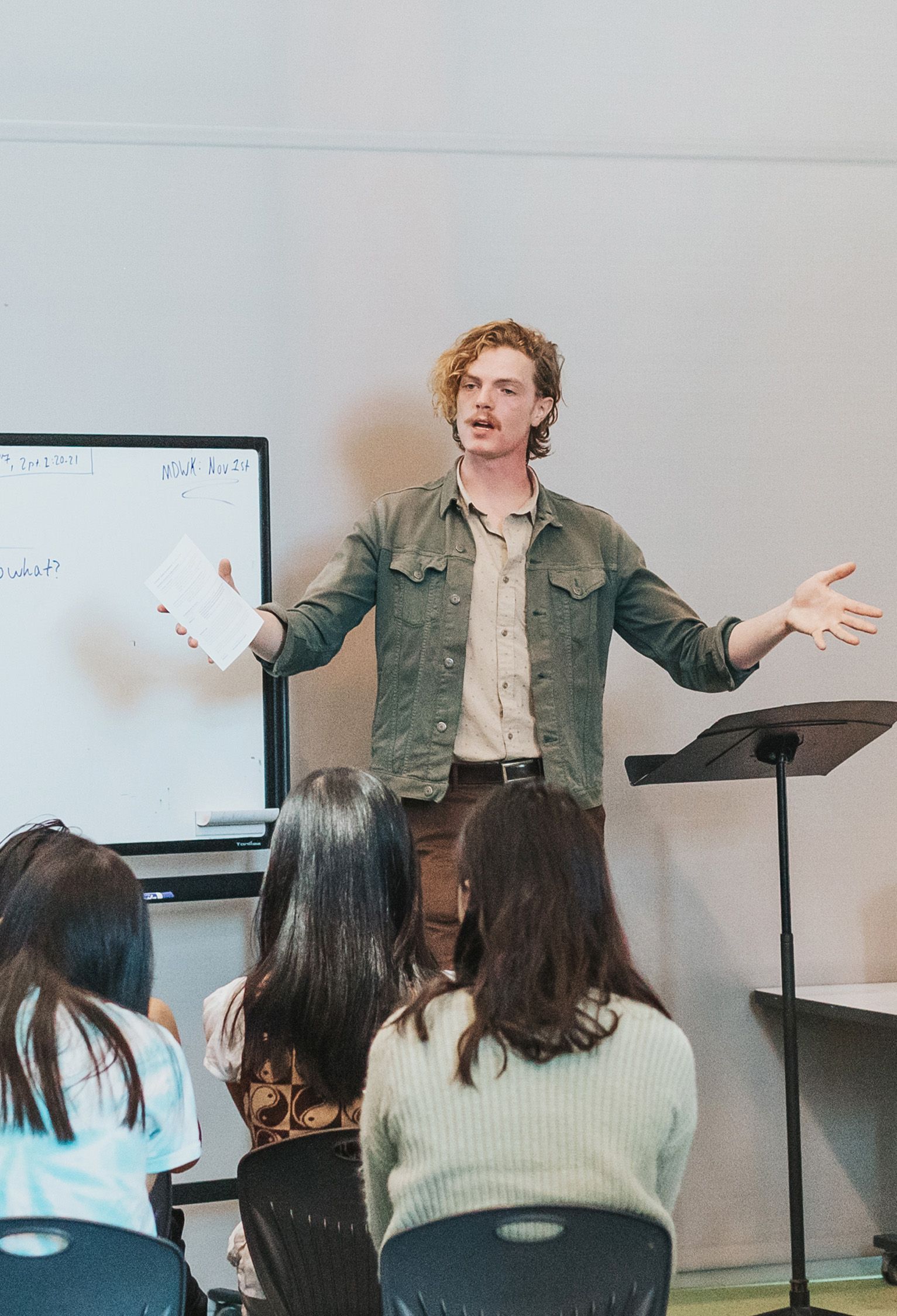 A man is giving a presentation to a group of people in a classroom.