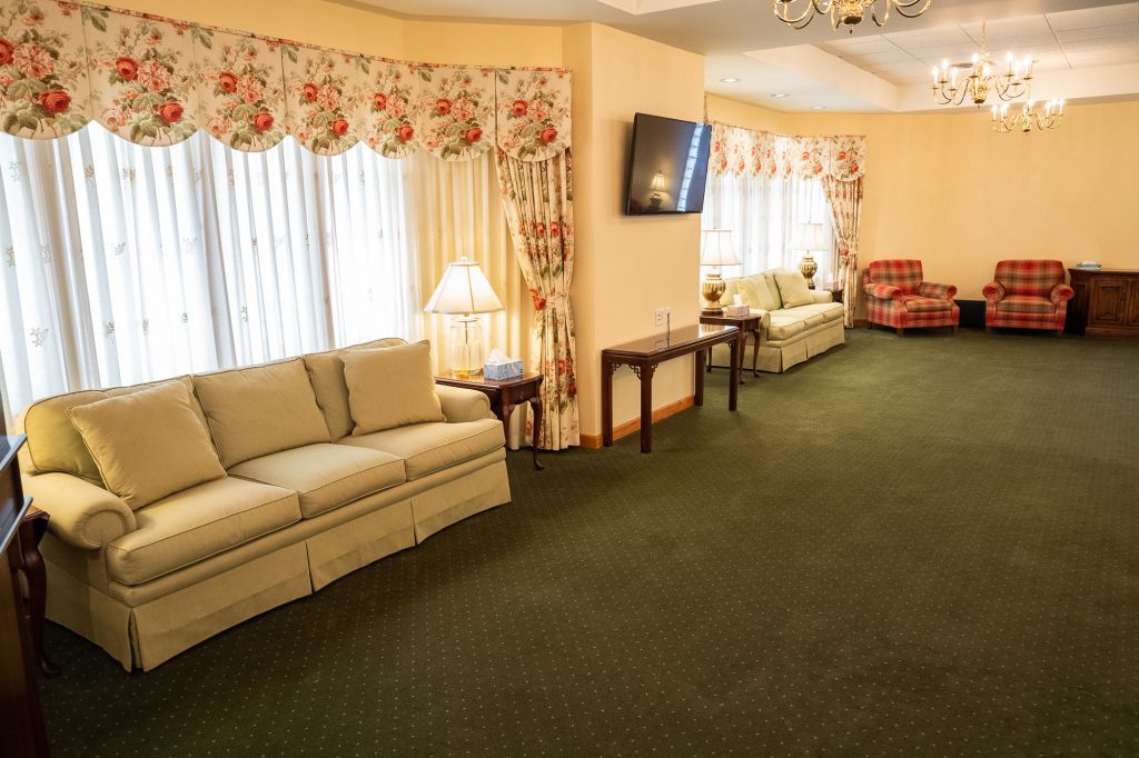 a living room with a couch , chairs , tables and a television .