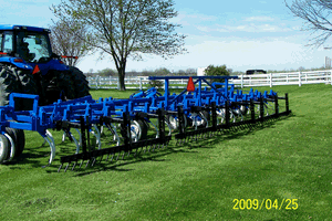 A blue tractor is parked in a grassy field