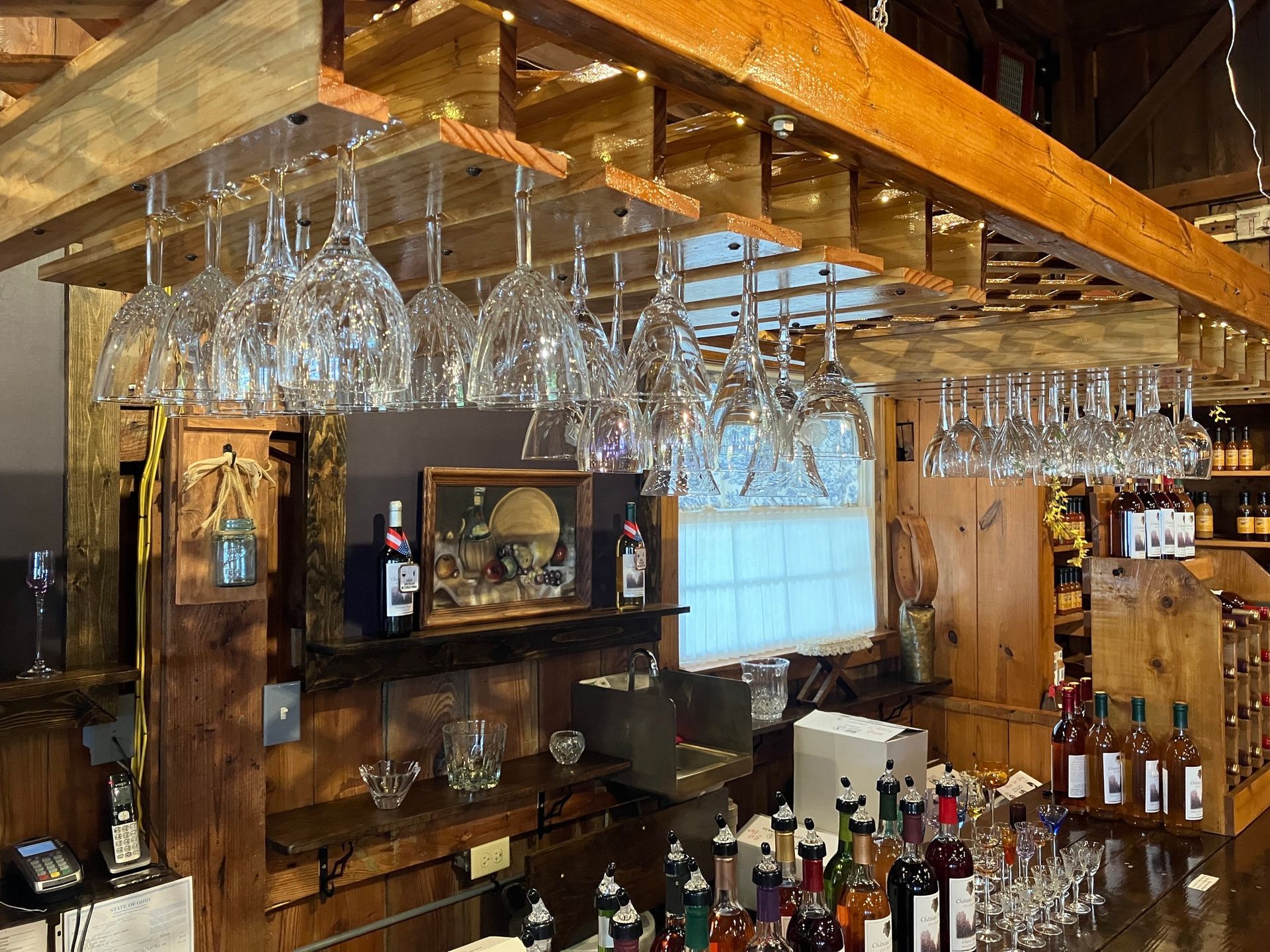 A bar with a lot of wine glasses hanging from the ceiling.