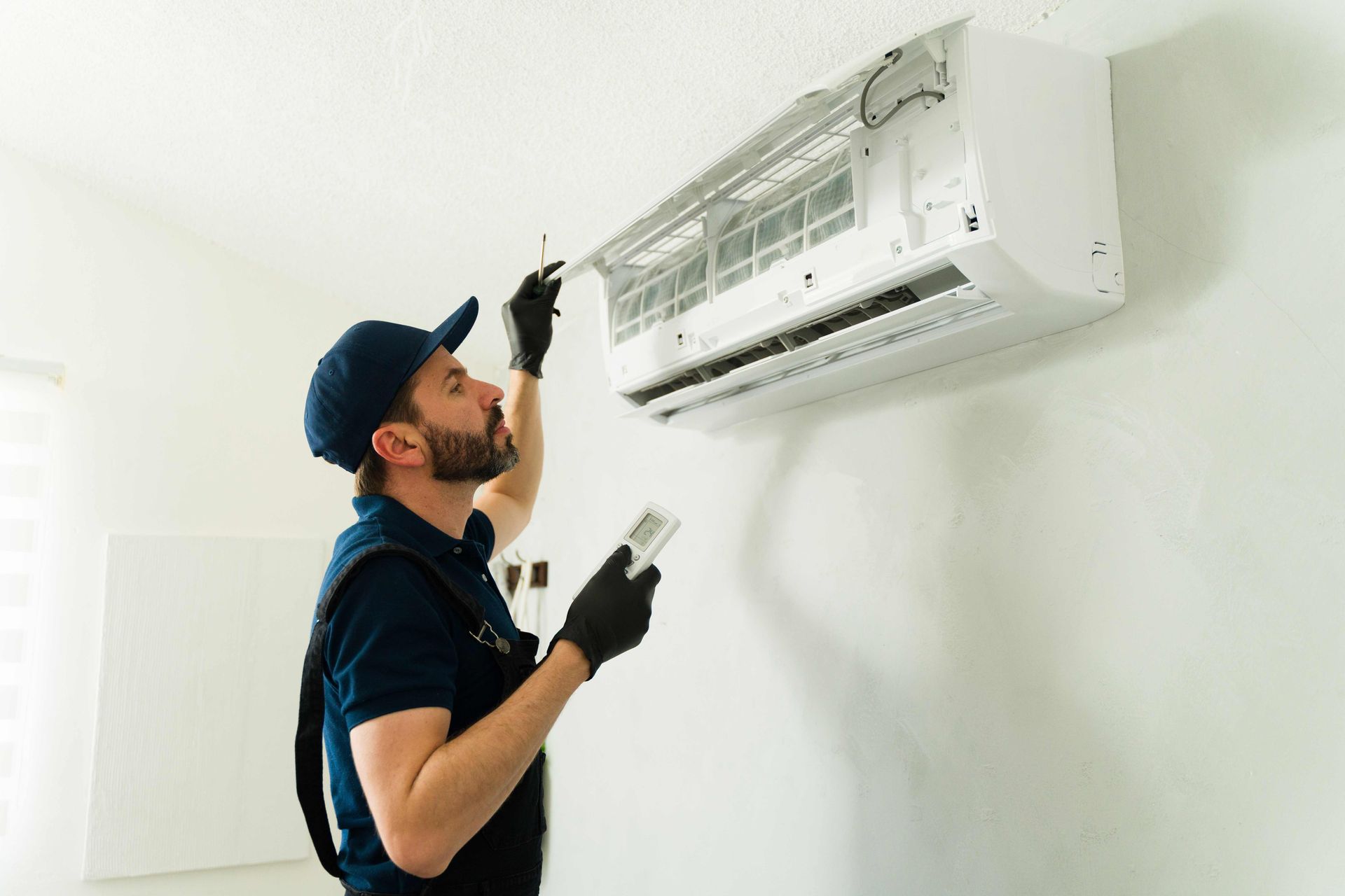 Male technician installing or repairing air conditioning unit. Male technician installing or repairing air conditioning unit.