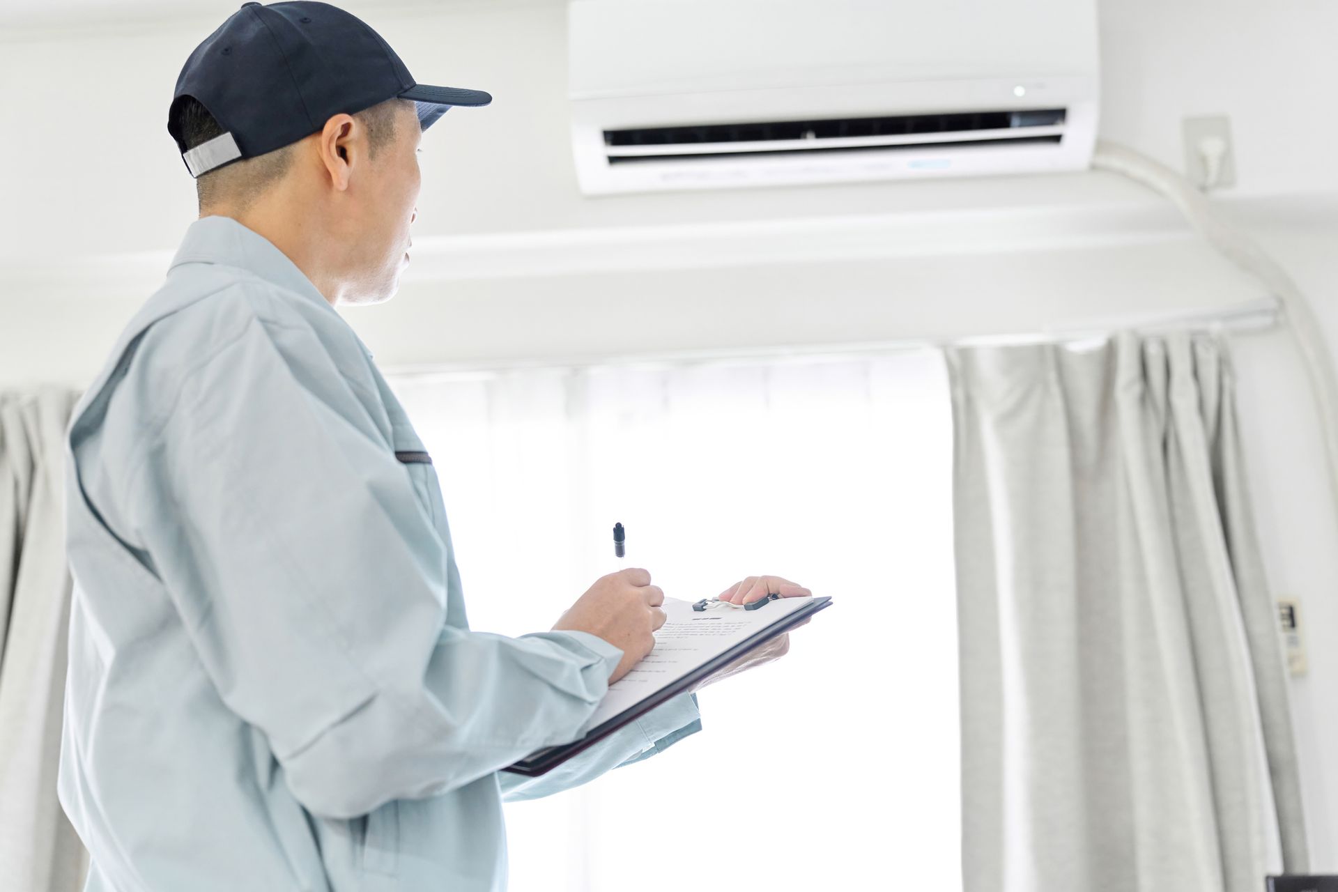 Worker inspecting air conditioner.