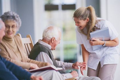 An elderly man laughing with a nurse