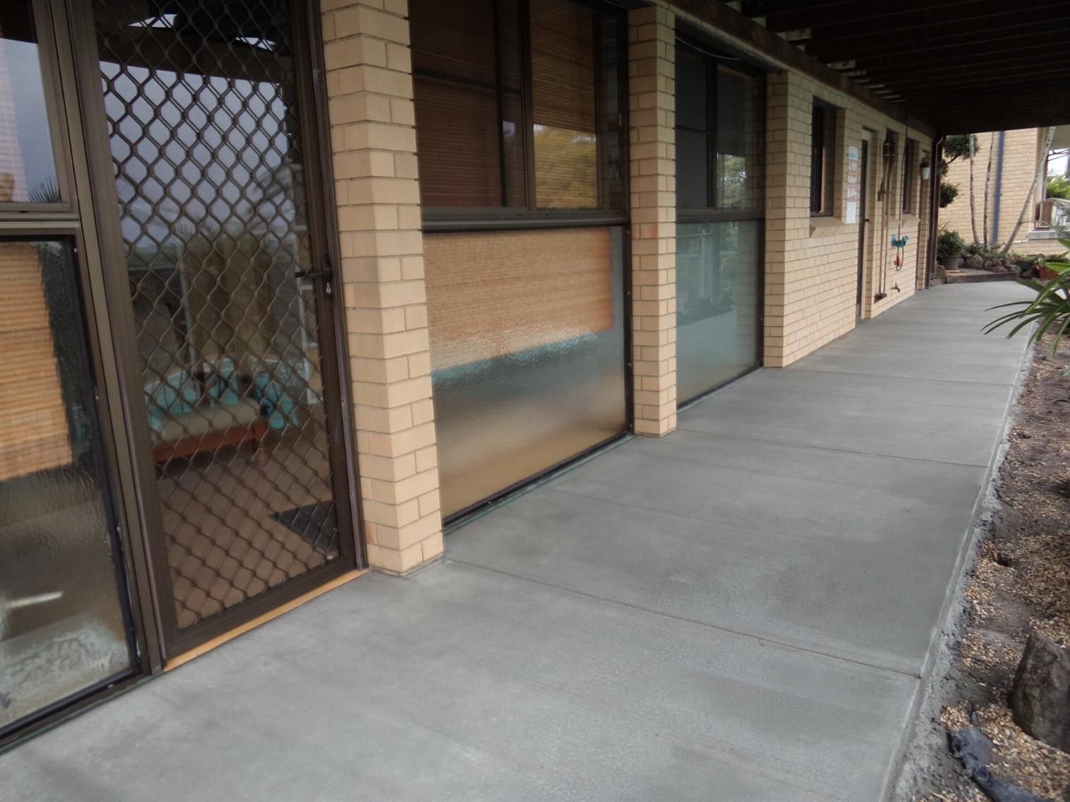 A Brick Building With a Walkway Leading to It — Wayne Hall Concreting in South Lismore, NSW