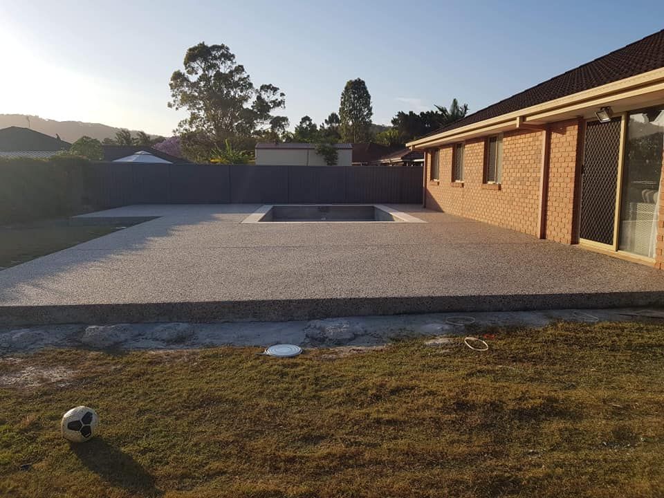 A Brick House With a Swimming Pool in the Backyard — Wayne Hall Concreting in Lismore, NSW