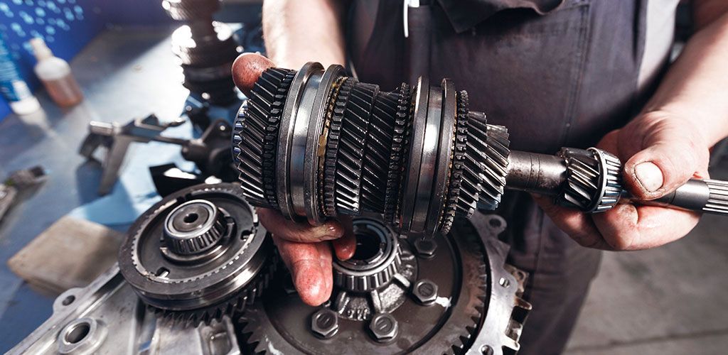A Man Is Working On A Gearbox In A Garage β Coffs Harbour Automotive In Coffs Harbour, NSW