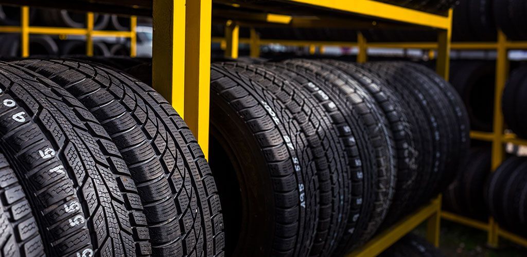 A Row Of Tires Stacked On Top Of Each Other On A Shelf β Coffs Harbour Automotive In Coffs Harbour, NSW