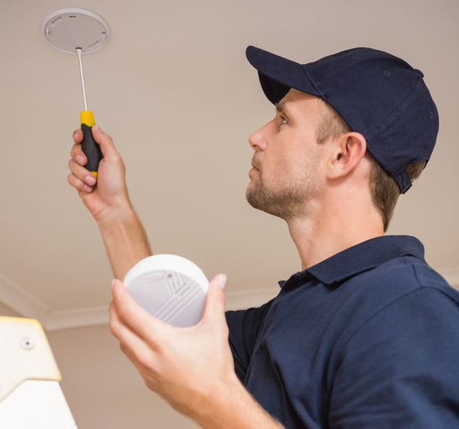 Man Installing a Ceiling Smoke Detector — Bladz Electrical in Maroochydore, QLD