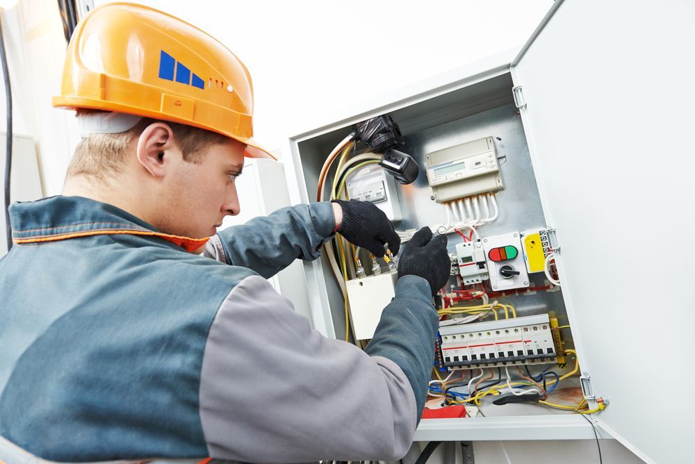 Electrician in Hard Hat Inspecting an Open Electrical Control Panel — Bladz Electrical in Maroochydore, QLD