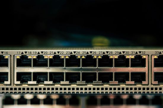 Close-up of a network switch with multiple Ethernet ports and port labels on a rack panel