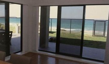Living Room with Sliding Glass Doors Leading to a Balcony Overlooking the Ocean - Penrith, NSW - ClearShield-Penrith