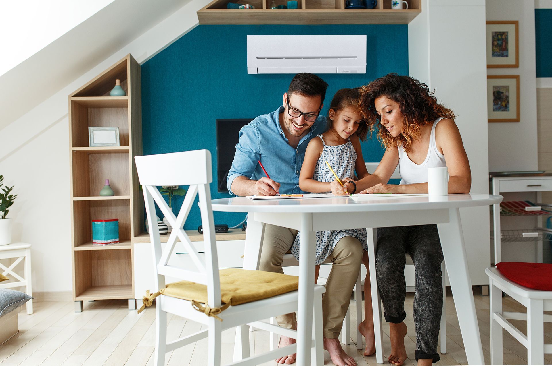 Family drawing at a white table in a modern living room with teal accent wall.— Elements Air & Refrigeration In Westcourt, QLD