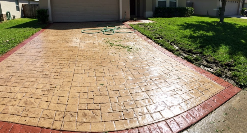 A durable stamped concrete driveway in Columbia MD featuring a cobblestone pattern and brick border.