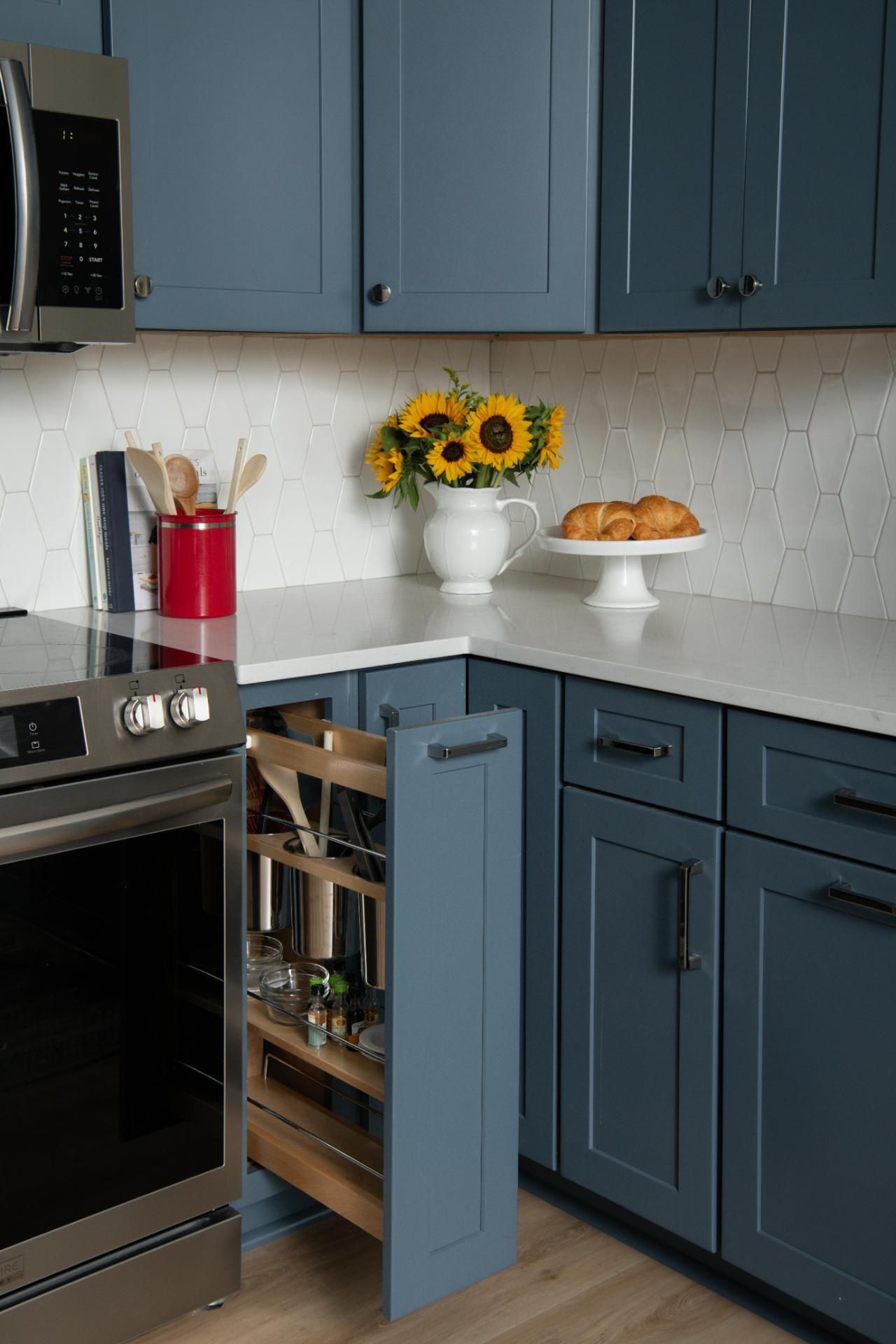 Blue kitchen with pull-out spice rack, white countertops, and sunflowers | Matthews, NC | An Inspiring Home