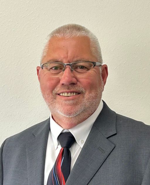 A man in a suit and tie is smiling for the camera.