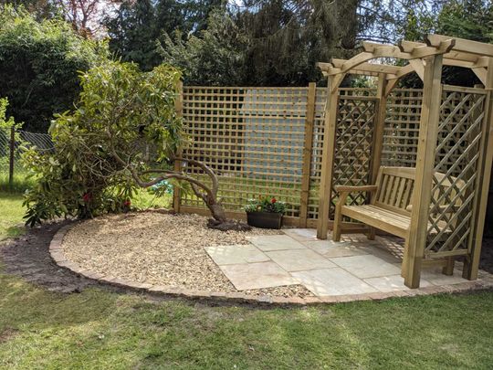 Get in touch for garden designs in Surrey Garden with small patio and garden bench