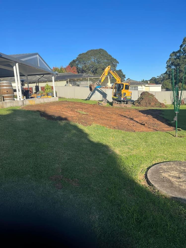 A Yellow Excavator is Digging a Hole in a Yard — BeCivil in Tomerong, NSW