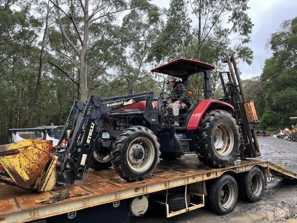 A Red Tractor is Sitting on Top of a Trailer — BeCivil in Tomerong, NSW