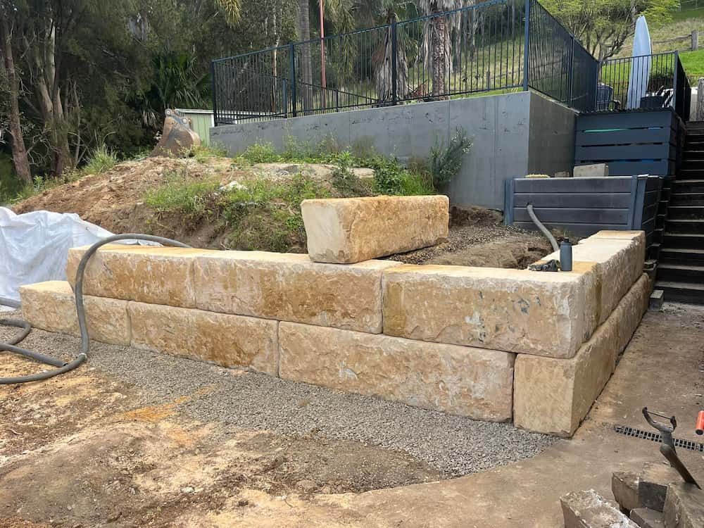 A Stone Wall is Being Built in the Dirt in Front of a House — BeCivil in Tomerong, NSW