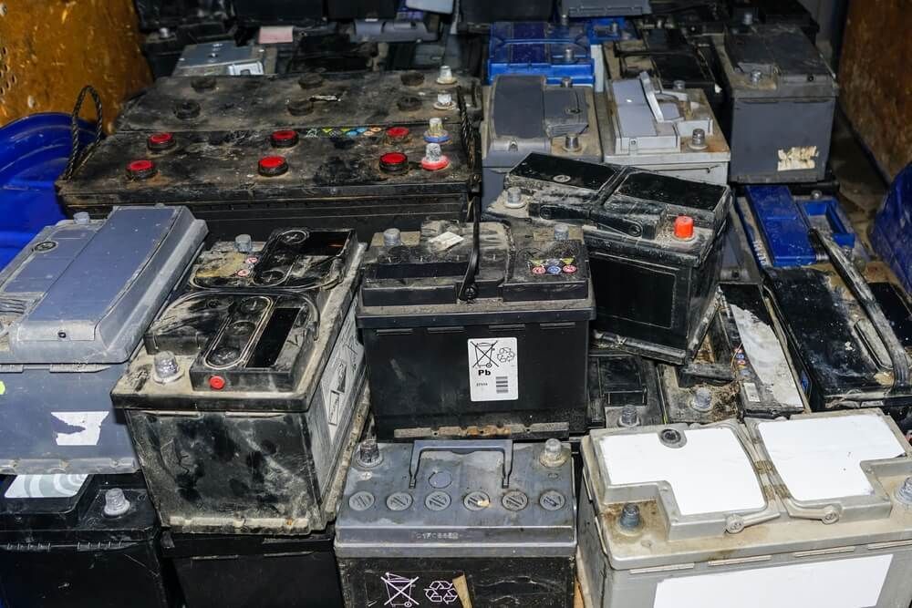 A Bunch Of Old Batteries Are Stacked On Top Of Each Other — Coast 2 Coast Batteries in Gosford, NSW