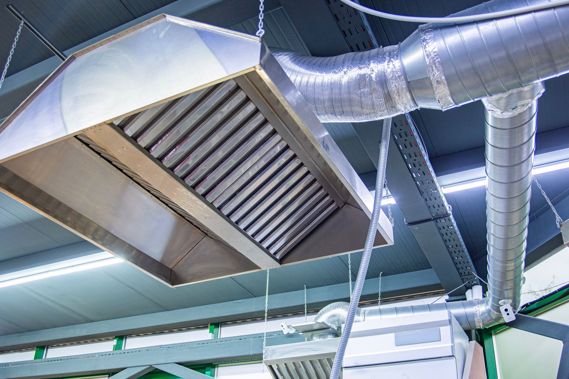 Ceiling HVAC vent and silver ductwork in an industrial interior