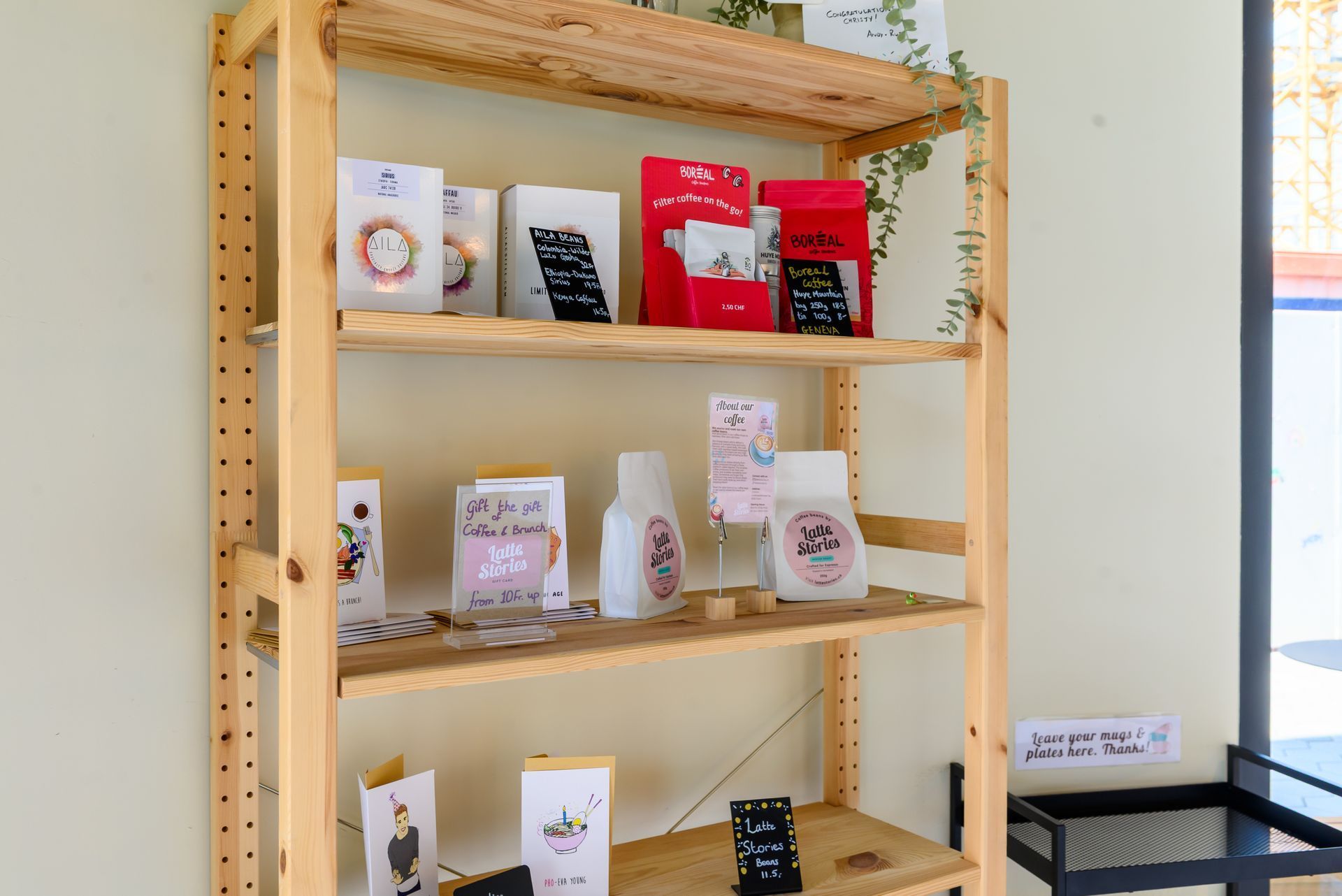 Wooden shelf display with assorted packaged products in a bright retail space
