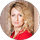 Blonde woman in a red top smiling against a light background