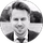 Black-and-white portrait of a smiling man in a suit and tie.