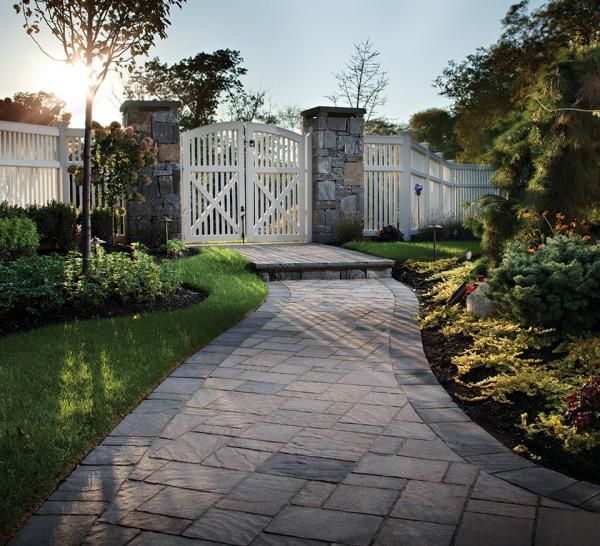 A brick walkway leads to a white gate