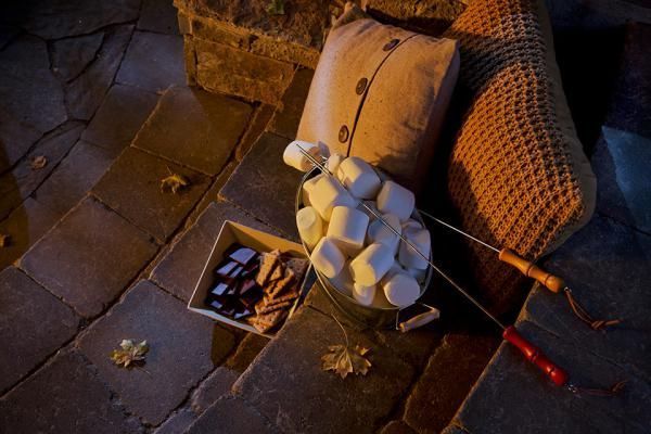 A bucket of marshmallows is sitting on the ground next to a chair.