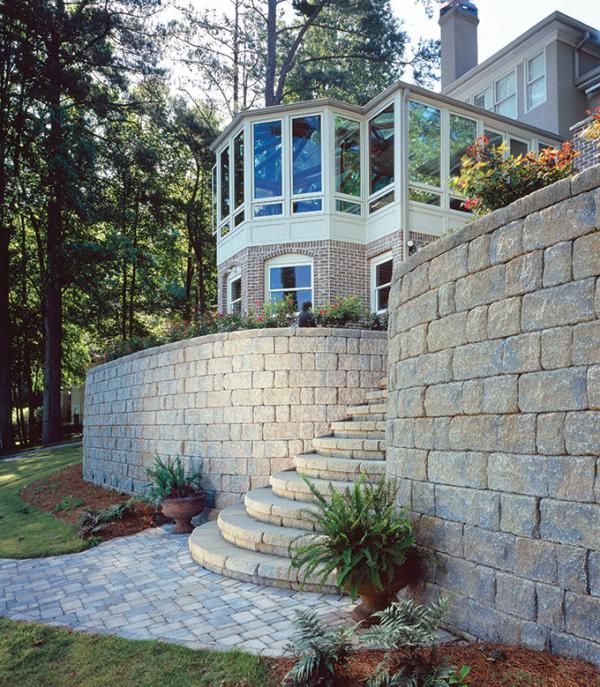 A stone wall with stairs leading up to a house