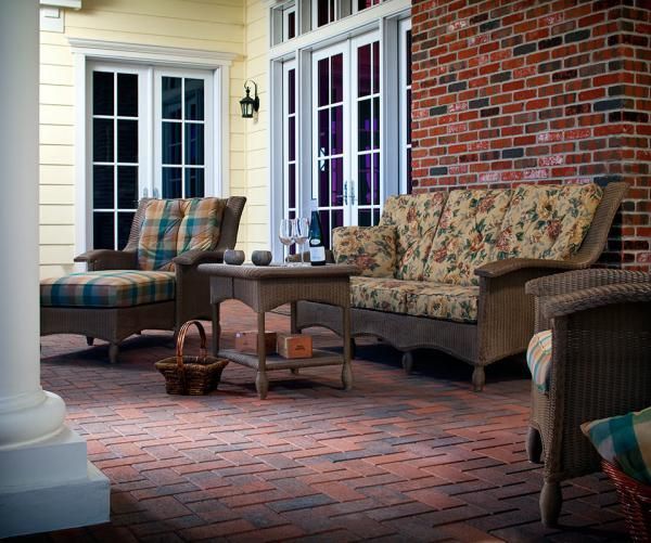 A patio with furniture and a brick wall