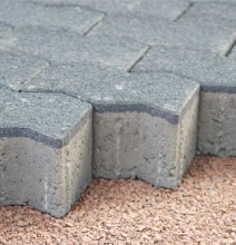 A close up of a brick pavement on a gravel surface.
