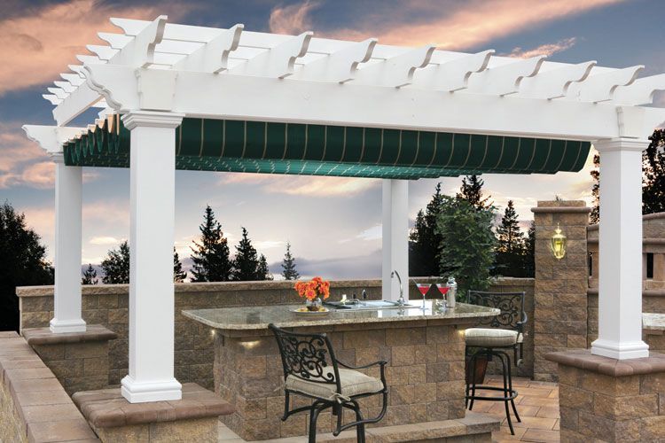 A white pergola with a green awning over a patio