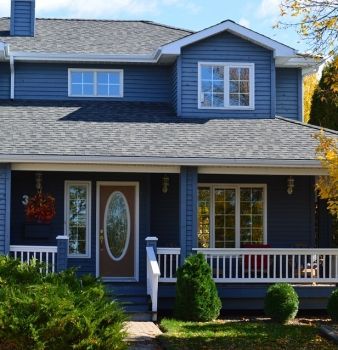 A blue house with a porch and the number 3 on the front