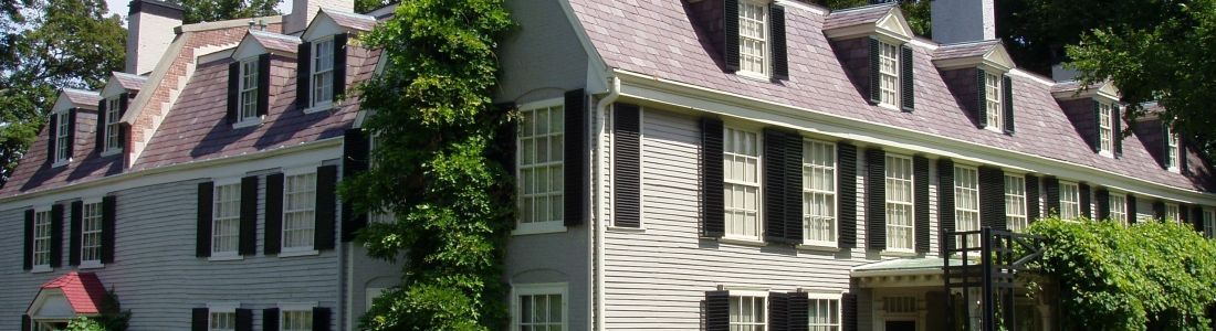 A white house with a pink roof and black shutters