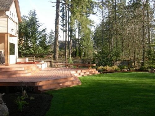A house with a large lawn and a wooden deck