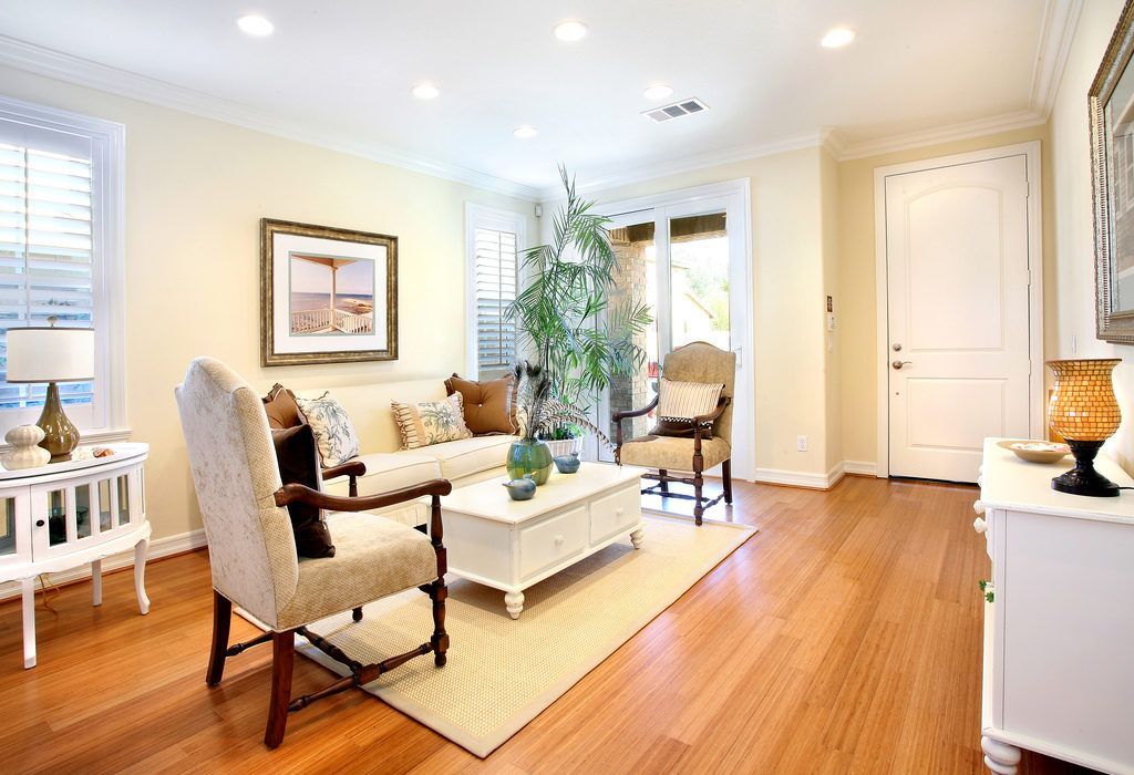 A living room with hardwood floors and white furniture
