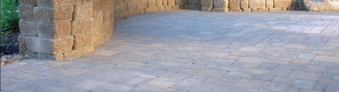 A brick walkway with a stone wall in the background.
