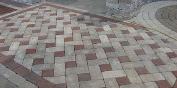A brick walkway with a herringbone pattern on it
