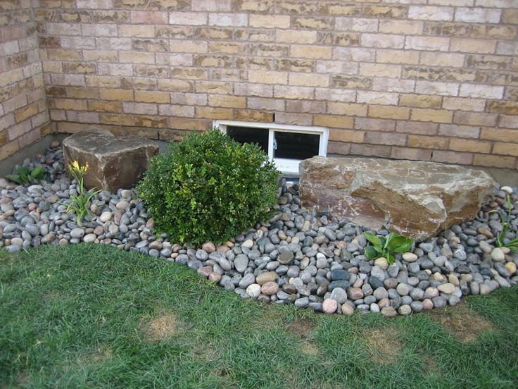 A rock garden in front of a brick wall