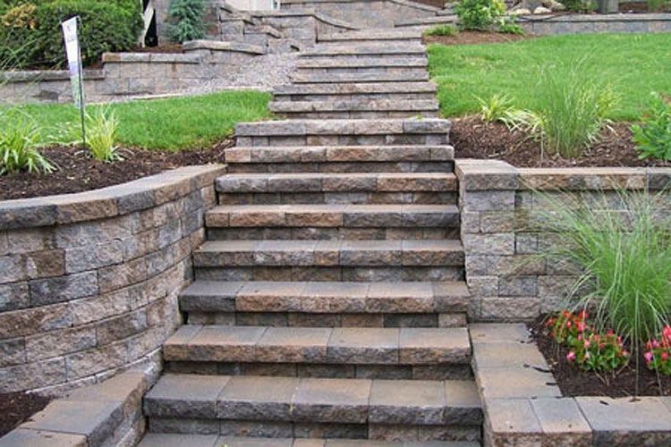 A set of stairs leading up to a lush green yard.