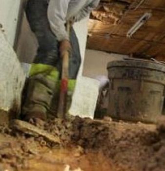A man is digging a hole in the ground with a shovel.