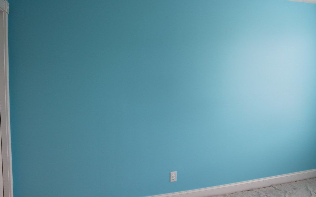 A room with a light blue wall and white trim.
