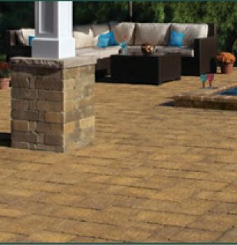 A brick patio with a couch and a table