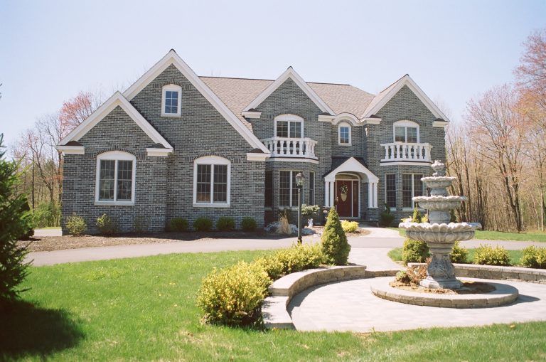 A large house with a fountain in front of it