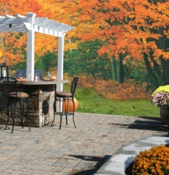A patio with a pergola and a table and chairs