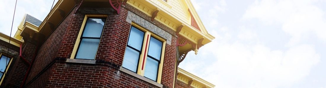 A brick building with blue windows and a yellow roof.
