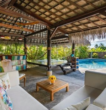 A living room with a couch and a table next to a pool